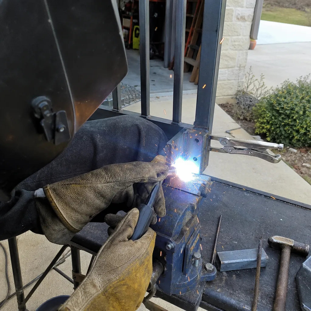 Professional welding repair on metal gate components in a workshop in Euless, TX
